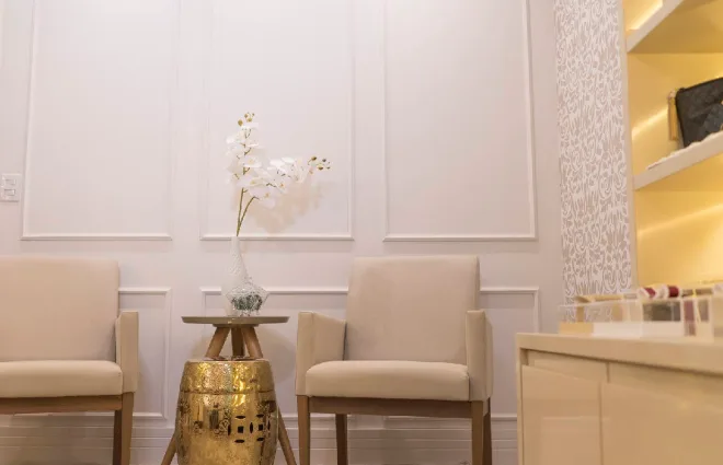 Showroom do ateliê DIAMOR em Vitória, com boiserie branca e poltronas bege